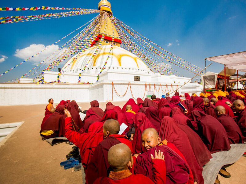71161824-Buddhist-monks-praying-around-temple-at-Bouddha-Boudhanath-UNESCO-World-Heritage-Site-Kathmandu-Nepal-Asia